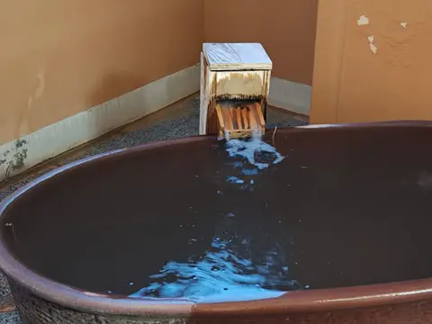 個室露天風呂の陶器風呂に注ぐ湯