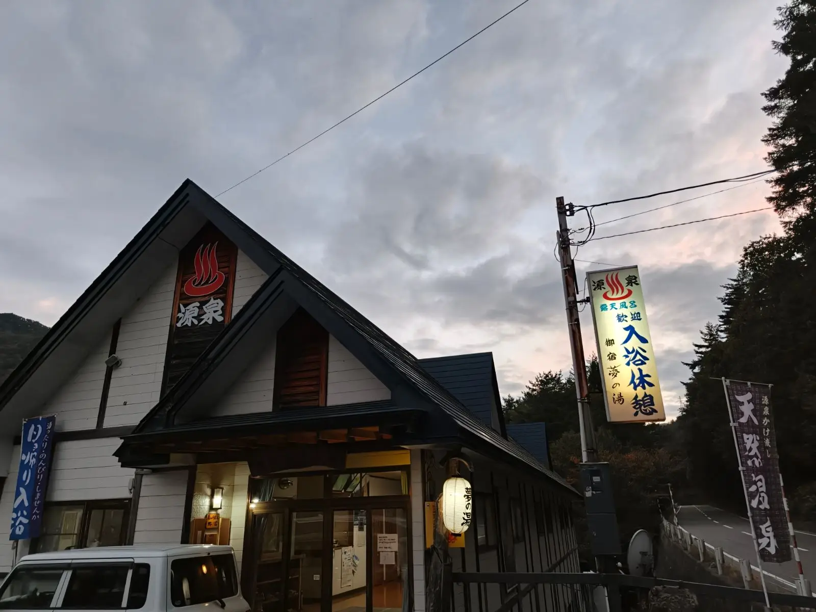 夕暮れの御宿 夢の湯の外観と入浴案内の看板