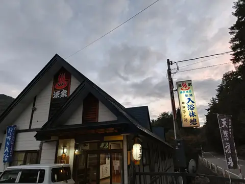 夕暮れの御宿 夢の湯の外観と入浴案内の看板